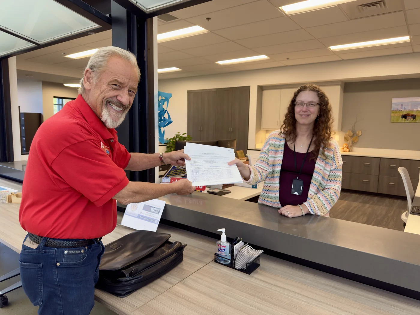 Former Mayor Doug Tisdale hands his nominating petitions to Cherry Hills Village City Clerk Laura Gillespie