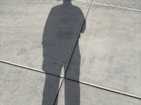 A shadow cast on pavement at the community event
